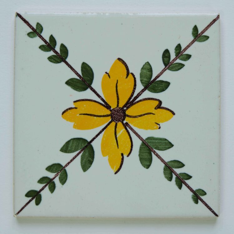 Handmålat kakel med gul blomma